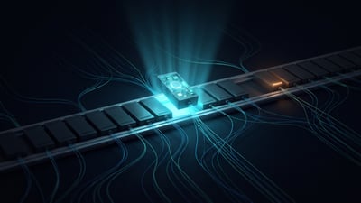 A rail of dim modular plug-in blocks with one lifted out under an inspection beam, filaments running from each into the dark